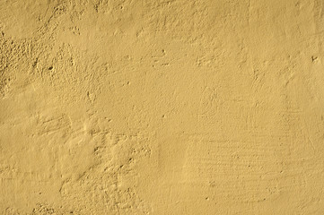 Ocher house rough plastered facade wall closeup as background