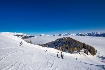 Fototapeta na wymiar Skiiers on the ski slopes in Kitzbühel ski resort in Tyrolian Alps, Austria