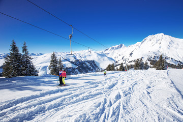 Fototapeta na wymiar Skiers on the lift in Kitzbühel ski resort, Tyrolian Alps, Austria