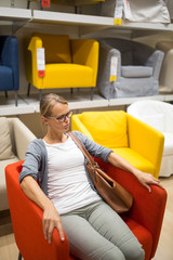 Pretty, young woman choosing the right furniture 