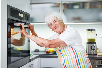 Senior woman cooking in the kitchen - eating and cooking healthy