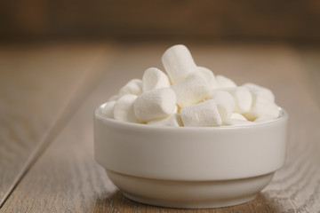 Fototapeta na wymiar white marshmallows in white bowl on table