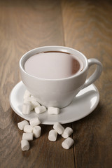 hot chocolate in cappuccino cup with marshmallows on wood table