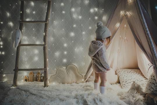 Little girl looking mesmerized by a wondrous tent