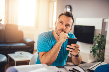 Man using smart phone and contemplating