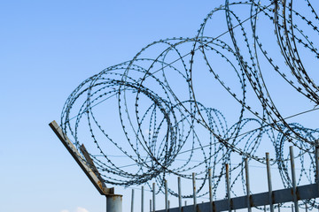 Barbed wire on the fence. Protective fencing specially protected object of barbed wire. Stamped barbed wire