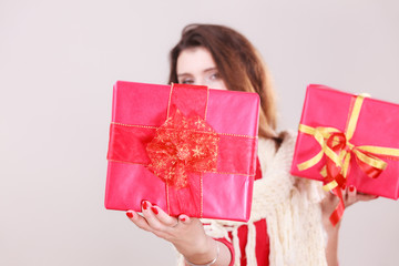 Woman holds red christmas gift boxes