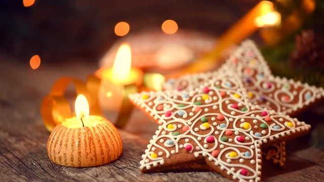 Christmas gingerbread cookies on wooden table decorated with garland and candles. Full HD 1080p video footage