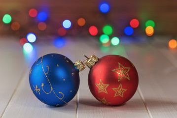 Fototapeta premium Decorative Christmas balls on wooden board with colorful bokeh background.