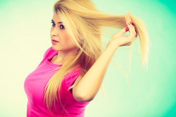 Fototapeta premium Blonde woman brushing her long hair