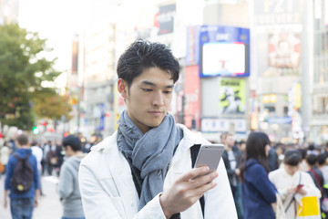 男性　渋谷駅前　渋谷スクランブル交差点前でスマホを操作　屋外