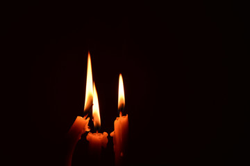 light candle burning brightly in the black background