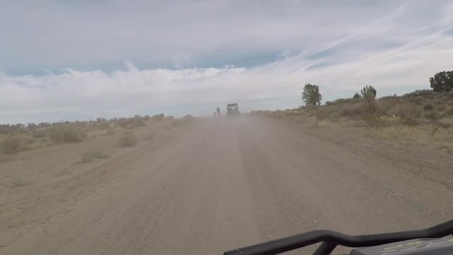 4x4 offroad following ATV motorcycle dusty road. Beauty seasonal recreation exploring high mountain and valley roads and desert trails. 4x4 4 wheel drive ATV. Outdoors and landscape.