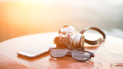 Camera for travel on table with sunlight. Beauty nature background