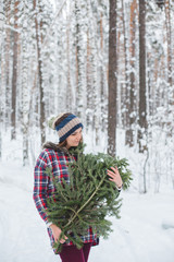girl keeps fir branches in the winter forest