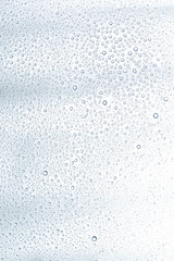 Water drop and droplet on mirror bright white and blue background