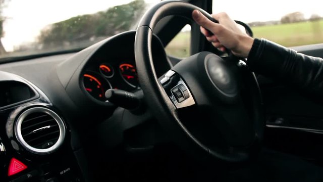 Young modern British male driving on road