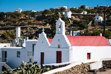 Chapel with red roof on Mykonos facing towards a hill