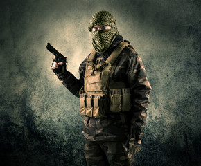 Portrait of a heavily armed masked soldier with grungy backgroun