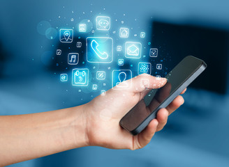 Hand holding smartphone with mobile app icons