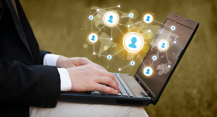 Close up of hand with laptop and social media icons