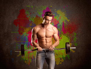 Strong guy with colorful paint wall and weight