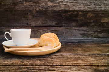 coffee mug with slice bread and wooden spoon on wood plate and rustic table breakfast