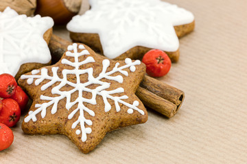 christmas homemade gingerbreads in star shape and red berries on wrapping paper background