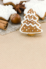 christmas gingerbread cookies and nuts on brown striped wrapping paper background