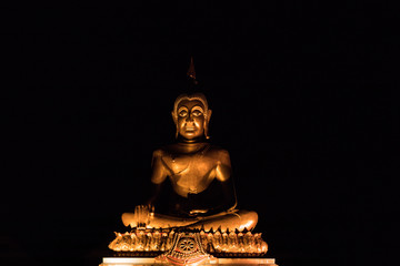 Golden Buddha statue with light on dark background. 
buddha image used as amulets of Buddhism religion.

