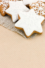 homemade star shaped christmas gingerbread cookies on brown striped paper background 
