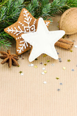 christmas gingerbread cookies, nuts and green fir tree branch on wrapping paper background