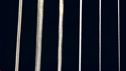 All six guitar strings bring strummed and seeing them vibrate to echo out the music. Macro shot. - Powered by Adobe