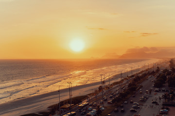 Top view of the ocean, beach, coastline, road and far hills, dramatic and colorful evening, Rio de Janeiro, Brazil