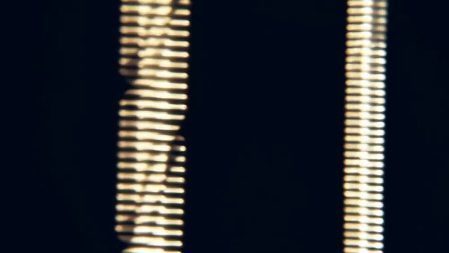 Extreme closeup of guitar strings vibrating after they have been strummed