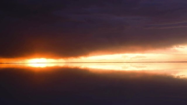 夕日が沈む雨季のウユニ塩湖