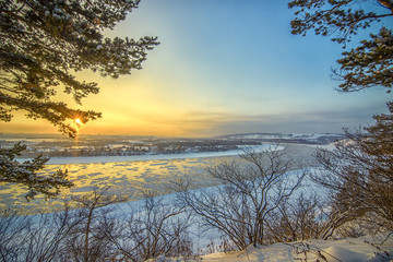 Fototapeta na wymiar Beautiful frosty sunset on frozen river watching from winter for