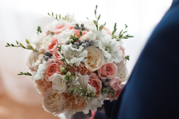 man holding a bridal bouquet