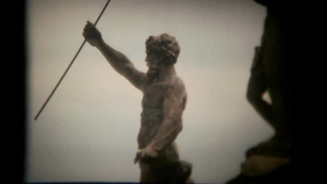 The silhouette of a statue in a public park. Vintage shot.