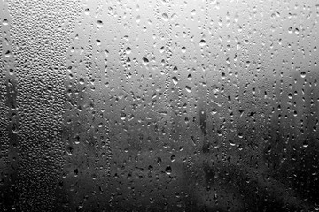 Rain drops on window close-up in black and white