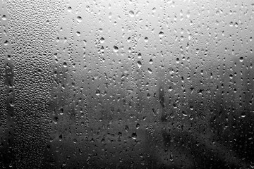 Rain drops on window close-up in black and white