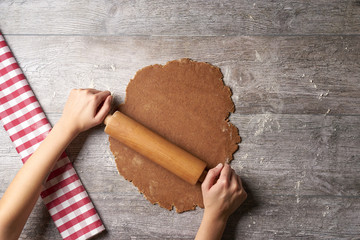 Hands rolling out Gingerbread dough from above, sideways in