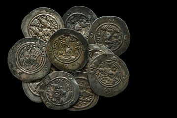 Pile of ancient silver coins isolated on black