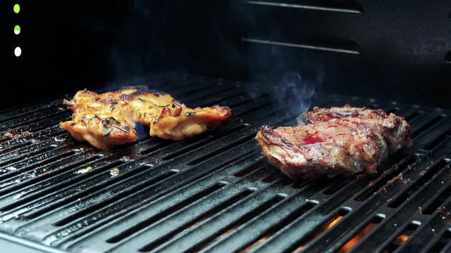 man prepares meat (chicken and beef) on the grill - closeup