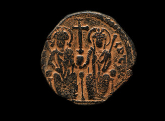 Ancient copper coin with cross and two figures