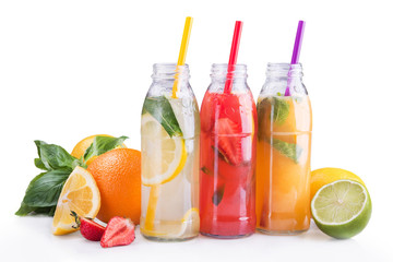 summer lemonade bottles with lemon, strawberry and orange fruit.