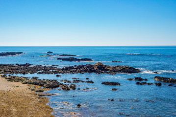 Tropical sea ocean beach bay cove rock stone shore coast blue water sunny horizon skyline