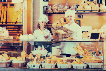 Smiling man and girl selling pastry and loaves