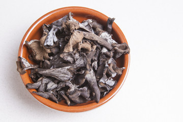 Clay bowl full of Horn of Plenty mushrooms