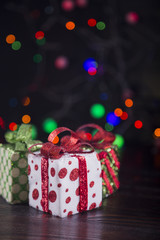Gift boxes with garland lights on colorful bokeh background